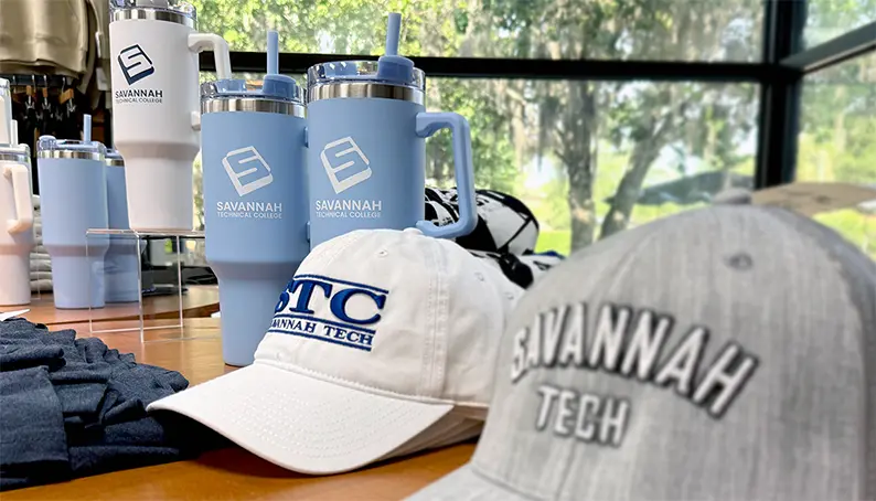 Savannah Tech caps and water bottles arranged on a desk